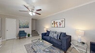 Located in Houston, TX, this two-story home offers a well-designed layout across two floors, providing comfortable living for residents. The main floor features a bright, tile-floored living room with crown molding, a ceiling fan, and natural light from a front-facing window — ideal for relaxing or entertaining. Adjacent to the living room, the dining area impresses with a chandelier, built-in shelving, wainscoting, and a pass-through window connecting directly to the kitchen. The galley-style kitchen is equipped with dark cabinetry, granite countertops, a stone tile backsplash, and black appliances. Three full bathrooms are distributed throughout the home, each featuring granite-topped vanities and tub-shower combinations. Upstairs, the three bedrooms are carpeted and outfitted with ceiling fans. The spacious primary bedroom features vaulted ceilings and an open closet with built-in shelving, offering generous storage. Additional highlights include two staircases, hallways connecting key areas, a dedicated laundry space, and a balcony for outdoor enjoyment. The home's neutral color palette and consistent finishes create a cohesive and functional living environment throughout.