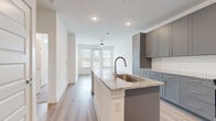 Located at 8402 IBM Drive in Charlotte, NC, this 1-bedroom, 1-bathroom unit offers a thoughtfully designed open-concept layout that maximizes its compact footprint. The combined kitchen and living area serves as the heart of the space, where light wood-tone flooring, recessed lighting, and a ceiling fan contribute to a clean, contemporary atmosphere. Large windows at the far end of the living area invite abundant natural light and provide exterior views.

The kitchen is a standout feature, equipped with gray shaker-style cabinetry, granite countertops, a white subway tile backsplash, and a full suite of stainless steel appliances including a refrigerator, range, microwave, and dishwasher. A central island with an undermount sink and matching granite surface provides additional workspace and casual dining potential.

The bedroom is carpeted for comfort and benefits from dual windows that bring in natural light and exterior views. A dedicated closet offers practical storage. The bathroom features a clean white tub-shower combination with a curved rod, a gray vanity with granite countertop, and light wood-tone flooring that complements the rest of the unit. Overall, the space presents a cohesive, modern aesthetic with consistent finishes throughout.