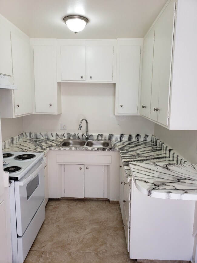 Kitchen with new counters, new stove/range and freshly painted cabinets - 2444 Pasadena Ave