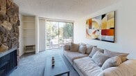 Located on S Beverly Glen Blvd in the desirable west Los Angeles neighborhood of 90025, this single-floor residence offers a well-organized layout designed for comfortable everyday living. The entryway features tile flooring and leads into the main living spaces through a clean, well-lit hallway. The spacious living room is carpeted and bathed in natural light, thanks to large sliding glass doors that open onto a private balcony overlooking lush greenery — a standout feature of the space. A built-in shelving unit adds practical storage to the living area. The galley-style kitchen is outfitted with white cabinetry, granite-style countertops, a full suite of white appliances including a refrigerator, electric range, and microwave, and tile flooring that carries a clean, functional aesthetic. The bedrooms are carpeted and generously sized, each equipped with a wall air conditioning unit and windows that allow natural light and outdoor views. Two bathrooms serve the space — one with a tub/shower combination enclosed by sliding glass doors and tile floors, and another with a wide vanity, mirrored medicine cabinet, and tile floors. Textured ceilings are present throughout, contributing to the classic character of this well-maintained Los Angeles residence.