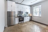 This 1140 square foot apartment in Memphis, TN, seamlessly blends modern amenities with industrial charm. The single-floor layout boasts two bedrooms and two bathrooms, offering a spacious and functional living environment. The property's standout feature is its soaring ceilings, complemented by large clerestory windows that flood the space with natural light.

The main living area impresses with its open-concept design, featuring polished concrete floors that add to the industrial aesthetic. A sleek, white kitchen with modern appliances and ample cabinetry anchors one end of this space. The bathrooms are elegantly appointed with contemporary fixtures, including glass-enclosed showers and hexagonal tile flooring.

Both bedrooms offer generous proportions, with the primary bedroom measuring 140 square feet. The apartment includes two closets for storage, one of which showcases exposed concrete walls, maintaining the industrial theme. A hallway connects the various rooms, ensuring a smooth flow throughout the space.

The property's design emphasizes clean lines and a neutral color palette, creating a canvas for personal style. The combination of high ceilings, abundant natural light, and open spaces cultivates an airy, loft-like atmosphere, making this apartment an ideal urban retreat in the heart of Memphis.