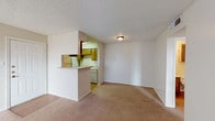 Located at 1305 Woodrow Rd in Slaton, Texas, this single-story home offers a functional and straightforward layout throughout its living spaces. The open living and dining area features warm, neutral-toned carpeting and a textured ceiling, with a pass-through kitchen bar that connects seamlessly to the main living space. A corner fireplace with a tiled surround serves as a focal point in the living room, adding a cozy architectural element to the area. The galley-style kitchen is well-equipped with abundant warm-toned wood cabinetry on both sides, light countertops, a double-basin stainless steel sink, an electric range, a dishwasher, and a full-size refrigerator. Wood-look flooring in the kitchen provides a practical and easy-to-maintain surface. The bedroom is carpeted and features a ceiling fan with a light fixture, along with a window that allows natural light to filter into the room. The bathroom includes a full tub and shower combo with clean white tile surround. Throughout the home, neutral wall tones and a consistent design palette create a cohesive and livable atmosphere. The single-floor layout ensures accessibility and ease of movement between all areas of the home.
