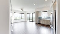 Located at 1777 Peachtree St NE in Atlanta, GA, this modern 2-bedroom, 2-bathroom residence offers a well-designed open-concept layout with clean lines and contemporary finishes throughout. A welcoming entryway with recessed lighting leads into the bright, open living and kitchen area, where large floor-to-ceiling windows and sliding glass doors flood the space with natural light and frame impressive views of the Atlanta skyline and surrounding treetops. The kitchen is outfitted with a full suite of stainless steel appliances, high-gloss white upper cabinets, warm wood-tone lower cabinets, a blue-gray subway tile backsplash, and white quartz countertops — all complemented by rich hardwood flooring. A ceiling fan adds comfort to both the living area and primary bedroom. The primary bedroom features a sliding glass door to a private balcony, wide-format windows with panoramic views, and light hardwood flooring. Each bedroom includes its own dedicated walk-in closet with wire shelving and plush carpet. The bedrooms are carpeted for added comfort. Both bathrooms are finished with wood-tone vanities, white quartz counters, brushed nickel fixtures, and clean tile flooring. The second bathroom includes a soaking tub and shower combination.