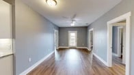 Located on Grand Park Ln in Thomasville, Georgia, this single-level 2-bedroom, 2-bathroom residence offers a thoughtfully designed layout with modern finishes throughout. Rich wood-look flooring flows consistently across the living spaces, complemented by cool grey walls and crisp white trim that create a clean, contemporary aesthetic.

The living room is a welcoming, open space featuring a ceiling fan, textured ceiling, and a front entry door that allows natural light to brighten the interior. Adjacent areas provide seamless access to the bedrooms and kitchen. The kitchen is equipped with white cabinetry, granite-look countertops, a tile backsplash, and stainless steel appliances, with a window offering pleasant outdoor views.

Both bedrooms are well-sized and bright, with the primary bedroom offering a generous walk-in closet fitted with wire shelving systems for ample storage. The second closet provides comparable functionality. Each bathroom is finished with granite-topped vanities, large mirrors, and a shower-tub combination with brushed nickel fixtures.

A dedicated laundry room with washer and dryer connections adds everyday convenience. The home also includes two closets, ensuring abundant storage throughout. With its cohesive design, practical layout, and quality finishes, this residence delivers comfortable and efficient living in Thomasville, GA.