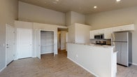 This single-floor residence offers a thoughtfully designed open-concept layout that seamlessly connects the kitchen and living areas. The kitchen is a functional centerpiece, featuring white cabinetry, granite-style countertops, a full suite of stainless steel appliances including a refrigerator, range, microwave, and dishwasher, and a peninsula that provides additional counter space and casual seating. Recessed lighting illuminates the space, complementing the natural light that filters in through windows near the entry door.

The living area is generously proportioned, with warm-toned, wood-look flooring that extends throughout the main living spaces, creating a cohesive and easy-to-maintain foundation. Elevated ceilings in the main area add a sense of openness and volume. A large walk-in storage closet off the main living space provides ample organizational capacity.

The bedrooms are carpeted for comfort and include ceiling fans, windows for natural light, and dedicated closet space. The bathrooms are finished with white cabinetry, granite-style vanity countertops, and wood-look flooring. One bathroom features a walk-in shower with a glass sliding door, while the other includes a tall linen storage cabinet. Neutral wall tones throughout the residence create a clean, versatile backdrop.