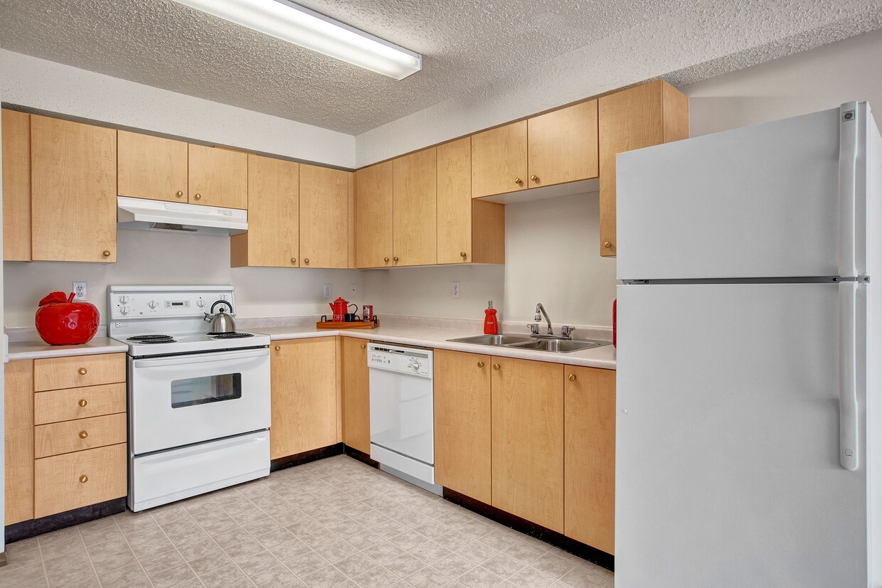 A kitchen with white appliances and light cabinetry - Villagio