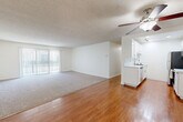 Located in Torrance, CA, this well-designed one-bedroom, two-bathroom residence offers a thoughtful layout across a single floor. The open living and dining area is a highlight, featuring warm hardwood flooring, a ceiling fan with integrated lighting, and a large sliding glass door flanked by vertical blinds that invite abundant natural light. The carpeted living zone transitions seamlessly into the hardwood-floored areas, providing a comfortable and versatile space.

The galley-style kitchen is outfitted with white shaker cabinetry, stone-look countertops, a subway tile backsplash, and a full suite of stainless steel appliances including a refrigerator, range, microwave, and dishwasher. A deep single-basin sink with a modern faucet completes the functional workspace.

The spacious primary bedroom features plush carpeting, a window with outdoor views, a textured ceiling, and a mirrored sliding-door closet offering generous storage. The bathrooms are finished with white vanity cabinetry, granite-style countertops, hardwood floors, and a tub-shower combination with a glass enclosure. Throughout the residence, a neutral color palette and clean finishes create a bright, cohesive ambiance.