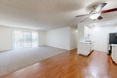 Located in Torrance, CA, this well-designed one-bedroom, two-bathroom residence offers a thoughtful layout across a single floor. The open living and dining area is a highlight, featuring warm hardwood flooring, a ceiling fan with integrated lighting, and a large sliding glass door flanked by vertical blinds that invite abundant natural light. The carpeted living zone transitions seamlessly into the hardwood-floored areas, providing a comfortable and versatile space.

The galley-style kitchen is outfitted with white shaker cabinetry, stone-look countertops, a subway tile backsplash, and a full suite of stainless steel appliances including a refrigerator, range, microwave, and dishwasher. A deep single-basin sink with a modern faucet completes the functional workspace.

The spacious primary bedroom features plush carpeting, a window with outdoor views, a textured ceiling, and a mirrored sliding-door closet offering generous storage. The bathrooms are finished with white vanity cabinetry, granite-style countertops, hardwood floors, and a tub-shower combination with a glass enclosure. Throughout the residence, a neutral color palette and clean finishes create a bright, cohesive ambiance.
