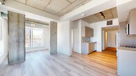 Located at 770 Somerset St W in Ottawa's vibrant Centretown neighbourhood, this two-bedroom, one-bathroom unit offers a contemporary industrial aesthetic across a well-utilized single floor. The open-concept living, dining, and kitchen area serves as the heart of the space, highlighted by striking exposed concrete ceilings with visible ductwork, sturdy concrete structural columns, and light-toned hardwood flooring throughout. Large windows flood the living area with natural light and frame views of the Ottawa skyline and surrounding neighbourhood rooftops, creating an airy, urban atmosphere.

The kitchen features warm-toned cabinetry, a clean subway-tile backsplash, and a functional layout that integrates seamlessly with the living and dining area. Both bedrooms are bright and well-proportioned, each with light hardwood floors, white walls, and windows offering outdoor views. The primary bedroom includes a built-in sliding-door closet and an exposed concrete accent wall, adding character. A dedicated entrance, in-unit laundry, and two closets add everyday practicality.

The full bathroom is finished with neutral large-format wall tiles and includes a soaker tub with a glass panel enclosure and a modern wall-mounted shower fixture, providing a clean and functional retreat.