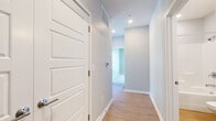 Located at 11848 Templeton Ct in Omaha, Nebraska, this single-floor residence offers a thoughtfully designed layout with two bedrooms, two bathrooms, and four closets. Light wood-look flooring flows through the main living, kitchen, and hallway areas, complemented by neutral gray walls and clean white trim throughout.

The open kitchen is equipped with stainless steel appliances, including a refrigerator, dishwasher, and range, alongside warm-toned cabinetry and granite-style countertops. A window above the sink area allows natural light to brighten the space. The adjoining living room features two large windows fitted with blinds, flooding the area with daylight and providing outdoor views.

The primary bedroom is generously sized, featuring a ceiling fan, a large window, and soft carpeting. It connects to a spacious walk-in closet with multi-tier wire shelving. The primary bathroom offers a dual-sink vanity with granite countertops, a large mirror, and a walk-in shower. The second bedroom also features plush carpet, a closet with built-in rod storage, and a bright window. A well-lit hallway with recessed lighting and a smart thermostat connects all areas of the residence efficiently.