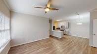 This ADA-compliant, ground-floor unit in Mobile, Alabama offers a well-designed, single-story layout with three bedrooms and two full bathrooms. The open-concept living and kitchen area forms the heart of the unit, featuring warm-toned luxury vinyl plank flooring, neutral gray walls, and ceiling fans that promote comfortable airflow throughout.

The kitchen is a standout feature, outfitted with gray shaker-style cabinetry, white countertops, a herringbone tile backsplash, and stainless steel appliances including a refrigerator, range, and dishwasher. A central kitchen island with an undermount sink provides additional prep space and acts as a natural divider between the kitchen and the living area. Recessed and flush-mount lighting ensures the kitchen remains bright and functional.

The bedrooms are generously proportioned, each with luxury vinyl plank flooring, ceiling fans, and windows fitted with blinds that allow for natural light. The two bathrooms include a tub-shower combination; notably, the primary bathroom is fully ADA-accessible, equipped with stainless grab bars and a roll-under vanity. The secondary bathroom features a soaking tub with built-in shelving. Throughout, crown molding and clean finishes contribute to a polished, cohesive aesthetic.