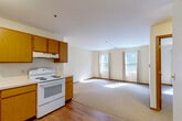 This one-bedroom, one-bathroom unit at 50 Boulder Hill Pass in Montgomery, IL offers a practical and well-organized single-floor layout. The open-concept kitchen flows directly into the living room, creating a cohesive, functional living space. The kitchen is equipped with warm oak cabinetry, white appliances including an electric range and refrigerator, a double sink, and durable hardwood flooring that extends underfoot. The living room features neutral carpet and large windows with curtain rods, allowing natural light to fill the space and create a bright, welcoming atmosphere. The bedroom is a comfortable, carpeted room with multiple windows that bring in additional daylight, and the unit is notably well-supplied with five closets, offering generous storage throughout. The bathroom includes a full tub-shower combo, a vanity with granite-style countertop, and hardwood flooring, with accessibility-friendly grab bars installed. A hallway connects the main areas of the unit efficiently. Neutral tones, warm wood accents, and clean finishes give the space a simple, move-in-ready appeal.