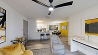 This well-appointed one-bedroom, one-bathroom residence in Union City, GA offers a thoughtfully designed open-concept layout across a single floor. The living, dining, and kitchen areas flow seamlessly together, unified by wood-look plank flooring and a striking bold yellow accent wall in the dining area that adds a vibrant focal point to the space. The living room features a modern ceiling fan, a sliding glass door with vertical blinds that allows natural light to filter in, and ample room for comfortable furnishings. The kitchen is outfitted with crisp white shaker cabinets, marble-look quartz countertops, a subway tile backsplash, stainless steel appliances including a refrigerator and electric range, and a breakfast bar with seating — ideal for casual dining or entertaining. The bedroom is a serene retreat with neutral tones and textured ceiling detail. The full bathroom includes a tub/shower combination, white vanity with marble-look countertop, and black matte hardware accents. A dedicated in-unit laundry room accommodates a full-size washer and dryer, complemented by overhead wire shelving. Storage is well addressed with two closets, including a spacious walk-in closet with multi-tier wire shelving systems.