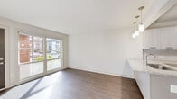Located at 1659 Monroe Dr NE in Atlanta's vibrant 30324 corridor, this thoughtfully renovated single-floor unit delivers a clean, contemporary aesthetic throughout. The open-concept living and dining area is anchored by rich, dark hardwood-style flooring that flows seamlessly across the space, complemented by crisp white walls and abundant natural light streaming through large sliding glass doors and windows that offer pleasant outdoor views of surrounding greenery.

The modern kitchen serves as a central hub of the layout, featuring a peninsula with granite-style countertops, sleek white cabinetry, a classic subway tile backsplash, and a full suite of stainless steel appliances including a refrigerator, range, and dishwasher. Stylish pendant lighting above the peninsula adds a refined touch.

The bedroom is generously proportioned, bathed in natural light, and equipped with a ceiling fan. Closet space is accessible nearby, adding functional storage to the layout. The bathroom presents a clean, minimalist design with neutral tile flooring, a modern vanity, and simple, polished fixtures.

A dedicated utility room houses the HVAC system and water heater. The overall design emphasizes modern simplicity, with consistent finishes and a bright, airy atmosphere throughout the entire space.