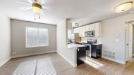 Located at 760 S 900 E in Salt Lake City, Utah, this efficiently designed one-bedroom, one-bathroom unit offers a thoughtful layout across a single floor. The open-concept living, dining, and kitchen area forms the heart of the space, filled with natural light streaming through multiple windows fitted with blinds. Light wood-look flooring and neutral wall tones create a clean, modern aesthetic throughout, complemented by a ceiling fan overhead.

The kitchen is a standout feature, boasting a galley-style design with crisp white upper cabinetry, dark lower cabinets, white quartz countertops, and a classic white subway tile backsplash. Stainless steel appliances — including a refrigerator, electric range, microwave, and dishwasher — provide a polished, functional finish. An in-unit washer and dryer are also conveniently housed within the kitchen area.

The bedroom offers a comfortable, carpeted retreat with a sliding double-door closet and a window that invites natural light. Three closets throughout the unit provide generous storage options. The bathroom features a full tub-shower combination surrounded by floor-to-ceiling white subway tile, brushed nickel fixtures, and wood-look flooring. A utility room and hallway complete this practical and stylish home.