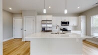 Located at 5101 Magnolia Lake Dr. in Westerville, Ohio, this single-floor residence offers a clean, contemporary design throughout. The open-concept living area flows seamlessly into the kitchen, where light hardwood-style flooring unifies the space and enhances its bright, airy feel. The kitchen is a standout feature, boasting white shaker-style cabinetry, a classic subway tile backsplash, stainless steel appliances including a French door refrigerator and range with microwave, and a large quartz-topped island with an undermount sink and pendant lighting above — ideal for both cooking and casual entertaining. The living area extends to a private outdoor balcony through sliding glass doors, bringing in abundant natural light and outdoor views. The bedrooms feature the same warm hardwood-style flooring, neutral gray walls, and well-sized windows fitted with blinds that allow for flexible natural light control. The bathroom is finished with modern touches, including a quartz vanity top, white cabinetry with brushed nickel hardware, a framed mirror, and tile flooring, complemented by a full tub-shower combination. Throughout the residence, recessed lighting, crisp white trim, and a cohesive neutral palette contribute to a polished, move-in-ready atmosphere.