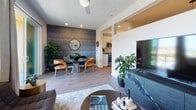Located at 375 Camino De La Reina in San Diego's Mission Valley neighborhood, this thoughtfully designed single-floor residence blends modern aesthetics with functional living. The open-concept living and dining area is a standout, featuring light wood-style flooring, a striking textured accent wall in the dining nook, and a ceiling fan overhead. The living space flows seamlessly into the kitchen, which is outfitted with white shaker cabinetry, light stone countertops, a white subway tile backsplash, stainless steel appliances including a gas range and built-in microwave, and a sleek undermount sink with a matte black faucet. The bedroom offers a serene retreat with warm pendant lighting, contemporary art accents, and a closet with sliding doors. The bathroom is well-appointed with a white vanity, matte black fixtures, a tub-shower combo, and recessed lighting. Throughout the residence, clean white walls and recessed lighting contribute to a bright, cohesive atmosphere. The layout, as seen in the dollhouse view, is efficiently organized with a hallway connecting the bedroom and bathroom to the main living areas, creating a smooth and intuitive flow throughout the home.