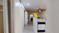 Located at 117 SE 16th Ave in Gainesville, FL, this 2-bedroom, 2-bathroom single-floor residence offers a well-organized layout designed for comfortable everyday living. The kitchen is fully equipped with white cabinetry, light-toned countertops, a full appliance suite including a dishwasher and electric range, and tile flooring that extends through the entry and kitchen areas. A peninsula counter opens to the dining area, which features a ceiling fan with recessed lighting overhead, creating a bright and functional space. The living room is carpeted and bathed in natural light from a sliding glass door that leads to a private balcony overlooking lush tree views, providing a serene outdoor retreat. Both bedrooms are comfortably sized, carpeted, and each equipped with a ceiling fan and a window that allows for natural light and ventilation. The primary bedroom offers ample space and privacy. The two bathrooms each feature a full tub-shower combination with tile flooring and built-in shelving. Louvered closet doors are found throughout the unit, adding a consistent design detail. The overall ambiance is light, neutral, and functional, making this a well-appointed residence in a convenient Gainesville location.