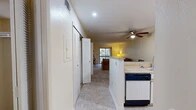Located at 117 SE 16th Ave in Gainesville, FL, this 2-bedroom, 2-bathroom single-floor residence offers a well-organized layout designed for comfortable everyday living. The kitchen is fully equipped with white cabinetry, light-toned countertops, a full appliance suite including a dishwasher and electric range, and tile flooring that extends through the entry and kitchen areas. A peninsula counter opens to the dining area, which features a ceiling fan with recessed lighting overhead, creating a bright and functional space. The living room is carpeted and bathed in natural light from a sliding glass door that leads to a private balcony overlooking lush tree views, providing a serene outdoor retreat. Both bedrooms are comfortably sized, carpeted, and each equipped with a ceiling fan and a window that allows for natural light and ventilation. The primary bedroom offers ample space and privacy. The two bathrooms each feature a full tub-shower combination with tile flooring and built-in shelving. Louvered closet doors are found throughout the unit, adding a consistent design detail. The overall ambiance is light, neutral, and functional, making this a well-appointed residence in a convenient Gainesville location.