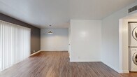 Located at 5601 E Fifth St in Tucson, AZ, this one-bedroom, one-bathroom unit offers a thoughtfully designed single-floor layout with modern updates throughout. Rich wood-style flooring flows continuously across the living room, hallway, bedroom, and kitchen, providing a cohesive and contemporary feel.

The spacious living room features a bold gray accent wall and a full-width sliding glass door fitted with vertical blinds, allowing abundant natural light and outdoor access. A second area off the living room offers additional flexibility with its own windows and ceiling fan, keeping the space bright and comfortable.

The kitchen is a standout feature, showcasing gray shaker-style cabinetry, granite-look countertops, and stainless steel appliances including a range and over-the-range microwave. Open shelving adds a practical, modern touch. The layout is efficient and well-organized, ideal for everyday cooking.

The bedroom is generously sized, fitted with a ceiling fan, and connects to a dedicated closet. White walls and clean lines keep the room feeling open and neutral. The bathroom includes a full tub-shower combo with a curved rod, wood-style flooring, and a vanity with ample counter space. A hallway connects all rooms, completing this clean and functional floor plan.