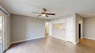 This 2-bedroom, 2-bathroom home in Kissimmee, Florida offers a practical and well-organized single-floor layout. Throughout the space, light wood-style flooring and neutral gray walls create a clean, cohesive aesthetic complemented by white trim and textured ceilings.

The open kitchen and living area serves as the heart of the home. The kitchen features white cabinetry, granite-style countertops, and black appliances including a full-size refrigerator and range, with a sliding door pantry providing additional storage. The adjoining living room is bright and airy, enhanced by a ceiling fan with light fixture and a sliding glass door that invites natural light and provides outdoor access.

Both bedrooms are generously sized with neutral tones and light flooring. The primary bedroom is notably spacious and includes direct access to a dedicated walk-in closet with dual hanging rods. The second bedroom also features its own closet for ample storage.

The two bathrooms share a consistent design, each appointed with white cabinetry, granite-style vanity countertops, light wood-look tile flooring, and a full tub-shower combination with white tile surround and brushed nickel fixtures. A connecting hallway ties all rooms together, providing a logical and efficient flow throughout the home.