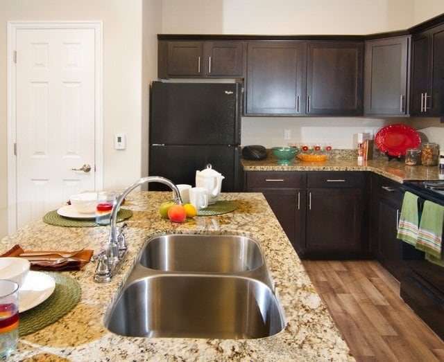 Modern Kitchen with Granite Countertops and Upgraded Black Appliances - Talavera at the Junction Apartments & Townhomes