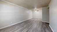 Located at 251 Eisenhower Dr in Biloxi, Mississippi, this single-floor, 2-bedroom, 2-bathroom residence offers a practical and well-organized layout. The living room greets you at the entrance with durable vinyl plank flooring in a neutral gray tone, a textured ceiling, crown molding, a ceiling fan, and a window that invites natural light and views of the surrounding greenery. The galley-style kitchen is efficiently designed with white cabinetry, light countertops, a stainless steel sink, and black appliances including a refrigerator and electric range. Both bedrooms feature plush carpeting, ceiling fans, and windows that provide natural light and outdoor views, creating comfortable and restful spaces. The primary bedroom offers a generous footprint with ample room for furnishings. The two bathrooms are clean and functional — one includes a vanity with white cabinetry, a large mirror, and warm-toned countertops, while the other features a full tub-shower combination with built-in shelving. A dedicated closet and hallway complete the layout. The overall design is neutral and move-in ready, with consistent finishes throughout that create a cohesive, low-maintenance living environment.