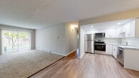 Located at 1469 W Irving Park Rd in Itasca, Illinois, this single-floor unit offers a well-organized and functional layout designed for comfortable everyday living. The open-concept living and dining area is highlighted by a combination of wood-look vinyl flooring and plush carpeting, creating a warm and inviting atmosphere. A large sliding glass door floods the living space with natural light and provides access to an outdoor view, while a wall-mounted AC unit and baseboard heating ensure year-round comfort.

The kitchen is thoughtfully appointed with crisp white shaker-style cabinetry extending to the ceiling for ample storage, light-toned marble-look countertops, and a full suite of stainless steel appliances including a refrigerator, electric range, and over-the-range microwave. Recessed lighting adds a clean, modern touch to the cooking space.

The bedrooms are carpeted for comfort, each offering generous proportions and closet space with bifold doors. Natural light filters in through window blinds, and baseboard heaters provide efficient warmth. The bathroom features a clean, all-white tub and shower surround with built-in corner shelving, maintaining a simple and functional aesthetic throughout the home.