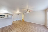 Located at 25469 Borough Park Drive in Spring, TX, this 2-bedroom, 2-bathroom single-floor unit offers a well-organized layout with light wood-style flooring running throughout every room, creating a cohesive and clean aesthetic. The open-concept living, dining, and kitchen area serves as the heart of the unit, where a peninsula-style kitchen features light wood cabinetry, white quartz-style countertops, stainless steel appliances including a refrigerator, electric range, and microwave, and ample upper cabinet storage with a pantry nearby. A chandelier accent illuminates the dining area, while a ceiling fan keeps the living space comfortable. Both bedrooms are well-proportioned, with the primary bedroom offering access to an en-suite bathroom and closet space, while both rooms feature ceiling fans and windows with outdoor views, allowing natural light to filter in. The two bathrooms are finished with white tile tub-shower combos, wood-style flooring, and clean, bright fixtures. Additional functional spaces include a utility room, laundry area, hallway, and multiple closets providing generous storage. The overall design is neutral and modern, with soft warm tones and a consistent material palette throughout.