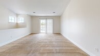 Located at 1401 Jorpark Cir in Spencerport, NY, this two-story home offers 2 bedrooms and 3 bathrooms across a well-organized layout. The entry level features a tiled entrance that leads upstairs to the main living area, where an open-concept kitchen and living room provide a bright, functional hub for the home. The kitchen is equipped with warm wood-toned cabinetry lining both sides of a galley-style layout, complemented by a white range, refrigerator, and tile flooring. A pass-through overlooking the living space adds an open feel to the kitchen area. The living room is generously sized, featuring neutral carpet, soft natural light, and sliding glass doors that open to an outdoor view. Both bedrooms are carpeted and filled with natural light from large windows with blinds. The spacious primary bedroom offers ample room for comfortable furnishings. Three bathrooms serve the home, including one with a full tub/shower combination, wood-toned vanity, tile flooring, and a large mirror. Throughout the home, neutral tones, clean white trim, and consistent finishes create a cohesive and move-in-ready aesthetic.