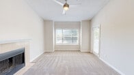 Located at 156 Bethesda Church Rd in Lawrenceville, GA, this single-story, one-bedroom, two-bathroom unit offers a well-designed layout across a comfortable footprint. The open living room is a standout, featuring soaring vaulted ceilings, a ceiling fan, plush carpeting, and abundant natural light from large windows. A tile-surround fireplace with a white mantel serves as a focal point, adding warmth and character to the space. The kitchen flows seamlessly from the living area and is equipped with white cabinetry, granite-look countertops, a peninsula sink, a skylight, and stainless steel appliances including a refrigerator, range, and microwave. Wood-look flooring runs throughout the kitchen for easy maintenance. The bedroom is generously sized, carpeted, and filled with natural light from a window with blinds. It is complemented by a spacious walk-in closet outfitted with wire shelving and built-in shelving units for ample storage. Both bathrooms feature granite-accented vanities and wood-look flooring, with one including a tub-shower combination. A dedicated laundry room with wire shelving overhead and washer/dryer hookups adds everyday convenience. A connecting hallway ties all rooms together cohesively.
