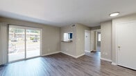 Located at 441 Manor Rd in Newport News, VA, this single-story residence offers a thoughtfully designed layout that maximizes functionality and comfort. The open living area is finished with durable wood-look flooring in a cool gray tone, neutral-painted walls, and sliding glass doors that invite natural light and provide views of the surrounding greenery. A charming pass-through window with a granite-style ledge connects the living space to the kitchen, creating an open, communicative feel between the two areas. The kitchen is well-equipped, featuring slate-blue cabinetry, granite-look countertops, a tile backsplash, black appliances including a dishwasher, and a window above the sink for added natural light. The spacious bedroom is carpeted for warmth and comfort, with two windows that brighten the room with outdoor views, along with access to generous closet space. The bathroom includes a full-size soaking tub and shower combination with clean white surroundings. Additional highlights include a dedicated laundry area, three closets for abundant storage, and a separate entry area with wood-look flooring. This residence blends practical design with modern updates throughout.