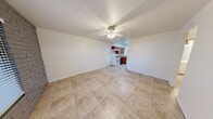 Located at 3325 East Pinchot Avenue in Phoenix, AZ, this single-story 2-bedroom, 1-bathroom home offers a practical and straightforward layout. The open living area flows directly into the kitchen, creating an efficient use of space. Durable tile flooring runs throughout the home, complemented by ceiling fans in every room that provide consistent air circulation — a practical feature well-suited to the Arizona climate. A distinctive design element throughout the home is the exposed painted brick walls, which add texture and character to both the living area and the bedrooms.

The kitchen features warm, medium-toned wood cabinetry, laminate countertops, a built-in range hood, and a white electric range with a double sink, offering a functional cooking space. Both bedrooms are modestly sized, each with a ceiling fan, closet, and windows that bring in natural light. The primary bedroom includes a closet accessible via a paneled door.

The bathroom is clean and straightforward, equipped with a full shower-tub combo with chrome fixtures. A connecting hallway links the bedrooms and bathroom, keeping the layout organized. Overall, this home presents a no-frills, well-maintained living space in a convenient Phoenix neighborhood.