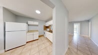 Located at 4843 Lake Arjaro Dr in West Palm Beach, Florida, this single-story, three-bedroom, three-bathroom home offers a practical and well-organized layout. Light tile flooring runs throughout the entire residence, lending a clean, cohesive look to every room. A long, well-lit hallway connects the living areas, guiding residents through the thoughtfully arranged floor plan.

The kitchen is outfitted with white cabinetry, a tile backsplash, laminate countertops, and white appliances including a refrigerator, electric range, and dishwasher. An in-unit washer and dryer add everyday convenience. A pass-through window connects the kitchen to the adjacent living room, enhancing the open feel between spaces.

The living room is spacious and bright, with neutral gray walls and access to a balcony that brings in natural light and outdoor views. The three bedrooms feature the same light tile flooring and soft gray walls, with the primary bedroom offering a generous footprint. Two closets provide dedicated storage throughout the home.

The three bathrooms vary in style — one features rich wood-look tile flooring and a tiled walk-in shower, while another offers a classic tub-and-shower combination with mosaic tile flooring and a sleek floating vanity. The home's clean, neutral palette and consistent finishes create a calm, move-in-ready atmosphere.