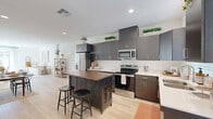 Located at 43738 Buena Vista Way in Lancaster, CA, this single-story, 3-bedroom, 2-bathroom home offers a thoughtfully designed layout with modern finishes throughout. Light wood-style flooring flows through the main living areas, lending warmth and cohesion to the space.

The kitchen is a standout feature, showcasing dark espresso cabinetry that extends to the ceiling, white quartz countertops, stainless steel appliances, and a central island with a butcher block top. Natural light filters in through a window above the sink, brightening the space considerably.

The open living room is bright and inviting, with recessed lighting and a clean, neutral palette that creates an airy ambiance. An adjacent dining area connects the kitchen and living spaces seamlessly.

The primary bedroom is a comfortable retreat, complemented by a generously sized walk-in closet with multi-tiered shelving and hanging rods. Two additional bedrooms offer ample natural light from large windows and share access to a full bathroom featuring a soaking tub and subway tile surround.

A dedicated laundry area and four closets throughout the home provide excellent storage. The attached garage offers additional utility space with an automatic opener. This home combines functional design with clean, contemporary finishes in a practical single-floor plan.