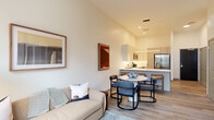Located at 1060 Bolivar Rd in Cleveland, OH, this thoughtfully designed one-bedroom, one-bathroom unit offers a well-appointed living experience with modern finishes throughout. The open-concept kitchen and living area serves as the heart of the unit, featuring light wood-tone flooring, elevated ceilings, and abundant natural light. The kitchen is outfitted with sleek two-tone cabinetry, white quartz countertops, stainless steel appliances including a French door refrigerator and electric range, and a peninsula with bar seating illuminated by a linear pendant light. The living area flows seamlessly from the kitchen, offering a bright and welcoming space with large windows that frame views of the Cleveland cityscape. The bedroom is a calm retreat with plush carpeting, a generous window overlooking the urban skyline, and access to a spacious walk-in closet equipped with wire shelving. The bathroom is finished with large-format tile flooring, a glass-enclosed walk-in shower, a warm wood vanity with a white quartz countertop, and an LED-backlit mirror. Clean lines, a neutral color palette, and contemporary details define the overall aesthetic of this urban residence.