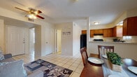 Located at 1602 Jacaman Rd in Laredo, Texas, this single-story unit offers a functional and well-organized layout designed for comfortable everyday living. The main living area features light-toned ceramic tile flooring that runs throughout the entire unit, creating a cohesive and easy-to-maintain foundation. A ceiling fan with a light fixture keeps the living room comfortable, which also includes a textured ceiling and neutral warm walls that lend a welcoming atmosphere.

The open layout connects the living room seamlessly to the dining area, which benefits from a window that allows natural light to filter in. Adjacent to the dining space, the kitchen is well-equipped with warm wood-toned cabinetry offering generous storage, black appliances including a full-size refrigerator and electric range, and a countertop workspace suited for everyday meal preparation.

The bedroom is a restful retreat, featuring a ceiling fan, a closet with double doors for storage, and continued tile flooring. The bathroom is outfitted with a single-sink vanity with wood cabinetry, a shower-tub combination, and decorative accents that add a touch of personality to the space. Overall, this unit presents a practical and comfortable living environment in a convenient Laredo location.