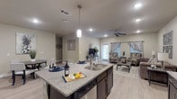 Located at 605 E Fish Creek Rd in Grand Prairie, Texas, this single-story residence offers a well-designed, open-concept layout with modern finishes throughout. The kitchen is a standout feature, equipped with rich dark cabinetry extending to the upper walls, granite-style countertops, stainless steel appliances including a refrigerator, range, and microwave, and light wood-look flooring that flows seamlessly into the living and dining areas. A central kitchen island with a double stainless steel sink and pendant lighting serves as both a functional workspace and a natural gathering point. The open living area provides a comfortable, airy atmosphere, complemented by a ceiling fan, recessed lighting, and windows that invite natural light. The bedrooms are carpeted and feature ceiling fans, windows with blinds and curtains, and ample space. Two bathrooms are present: one full bathroom with a soaking tub and shower combination, dark vanity cabinetry, and granite-style countertops, and a second bathroom featuring a single vanity with matching dark cabinetry and storage above. Neutral wall tones and consistent design elements throughout create a cohesive, contemporary aesthetic well-suited for comfortable everyday living.