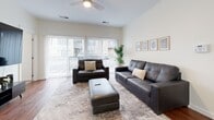Located at 1005 W 5th Ave in Columbus, Ohio, this one-bedroom, one-bathroom unit offers a well-designed, efficiently laid-out single-floor living space. The open-concept kitchen and living room serves as the heart of the unit, where rich hardwood flooring flows throughout. The kitchen is outfitted with dark espresso cabinetry, granite countertops, a subway tile backsplash, stainless steel appliances, and a central island with bar seating, illuminated by stylish pendant lighting. The living area is bright and airy, featuring a ceiling fan, large sliding glass doors with vertical blinds that invite an abundance of natural light and provide outdoor views. The bedroom offers plush carpeting, a window with natural light, and direct access to a spacious walk-in closet complete with wire shelving. The bathroom is finished with wood-look tile flooring, a granite-topped vanity with dark cabinetry, and a glass-enclosed walk-in shower with white tile surround. Additional conveniences include a dedicated laundry area, pantry, and utility room. The unit combines modern finishes with a functional layout, making it a practical and attractive living space in the heart of Columbus.
