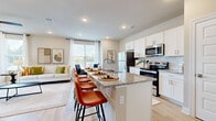 This efficiently designed 1-bedroom, 1-bathroom residence offers a thoughtful open-concept layout that maximizes every square foot. The combined living, dining, and kitchen area serves as the heart of the home, anchored by a sleek kitchen island with granite countertops and bar seating for multiple guests. White shaker-style cabinetry, a subway tile backsplash, and a full suite of stainless steel appliances — including a refrigerator, electric range, and microwave — complete the modern kitchen. Light hardwood-style flooring flows throughout the main living areas, complementing the bright, neutral color palette. The living room is filled with natural light from large windows and French doors, and is finished with recessed lighting and a ceiling fan. A dedicated dining area benefits from an oversized window with outdoor views. The bedroom offers a comfortable, well-lit retreat with a ceiling fan, natural light, and access to the full bathroom, which features granite countertops, white cabinetry, and a large mirror. A dedicated in-unit laundry area with a full-size washer and dryer adds everyday convenience. This residence combines clean, contemporary finishes with a functional floor plan.