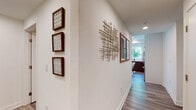 Located in the heart of Hollywood on N Cahuenga Boulevard, this single-floor residence offers a thoughtfully designed layout with a contemporary aesthetic. Wood-look flooring runs throughout, tying together each space with a warm, cohesive feel.

The living area is bright and open, featuring floor-to-ceiling windows and a sliding glass door that leads to a private balcony, flooding the room with natural light and offering outdoor views. Sheer gold-rod curtains add an elegant touch.

The kitchen is well-appointed with two-tone cabinetry — dark wood lower cabinets paired with crisp white uppers — white quartz countertops, a subway tile backsplash, and stainless steel appliances including a gas range, microwave, and dishwasher. A window above the sink brings in additional natural light.

Two bedrooms provide comfortable retreats, each with large windows, sheer curtains, and ample natural light. One bathroom features a wide vanity with dark wood cabinetry and a large mirror, while the second includes a shower-tub combination.

A well-decorated hallway connects the spaces, adorned with framed artwork and a sculptural wall accent, adding artistic character throughout the residence.