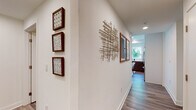 Located in the heart of Hollywood on N Cahuenga Boulevard, this single-floor residence offers a thoughtfully designed layout with a contemporary aesthetic. Wood-look flooring runs throughout, tying together each space with a warm, cohesive feel.

The living area is bright and open, featuring floor-to-ceiling windows and a sliding glass door that leads to a private balcony, flooding the room with natural light and offering outdoor views. Sheer gold-rod curtains add an elegant touch.

The kitchen is well-appointed with two-tone cabinetry — dark wood lower cabinets paired with crisp white uppers — white quartz countertops, a subway tile backsplash, and stainless steel appliances including a gas range, microwave, and dishwasher. A window above the sink brings in additional natural light.

Two bedrooms provide comfortable retreats, each with large windows, sheer curtains, and ample natural light. One bathroom features a wide vanity with dark wood cabinetry and a large mirror, while the second includes a shower-tub combination.

A well-decorated hallway connects the spaces, adorned with framed artwork and a sculptural wall accent, adding artistic character throughout the residence.