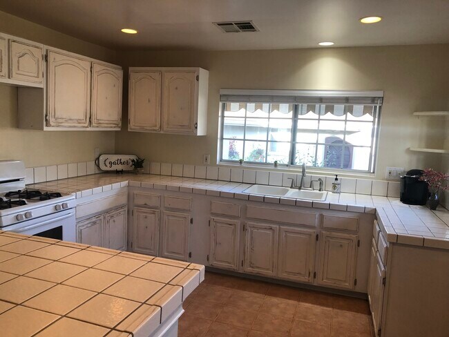 Esta amplia cocina con vistas al jardín cuenta con mucha encimera y armarios. - 2208 Gramercy Ave