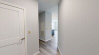 Located at 3 Gilbert Dr in Merrimack, New Hampshire, this well-designed one-bedroom, one-bathroom residence offers a clean, contemporary aesthetic throughout its thoughtfully arranged single-floor layout. Light gray walls and wood-look luxury vinyl flooring flow seamlessly from room to room, creating a cohesive and modern atmosphere.

The open-concept kitchen and living area serves as the heart of the home. The kitchen is outfitted with crisp white cabinetry, stainless steel appliances including a refrigerator, range, microwave, and dishwasher, as well as a central island with a contrasting gray base and white countertop. Pendant lighting above the island adds a stylish finishing touch, while recessed lighting ensures the space is well-illuminated.

The living area is bright and airy, featuring multiple large windows that invite generous natural light and provide views of the surrounding greenery. The bedroom offers a comfortable footprint, a double-door closet for storage, and the same warm wood-look flooring found throughout the unit.

The bathroom is finished with wood-grain tile flooring, a warm-toned vanity with ample drawer storage, and clean white walls that give the space a fresh, spa-like feel. A dedicated closet provides additional organization. The unit also features exterior access, with steps leading to a welcoming outdoor entry area.