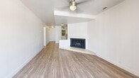 Located in Millcreek, Utah, this one-bedroom, two-bathroom single-level unit offers a well-organized layout designed for comfortable everyday living. The living room serves as the focal point of the home, featuring warm wood-look hardwood-style flooring, a ceiling fan, and a corner fireplace with a raised hearth and classic white mantel. A sliding glass door opens to a private balcony, allowing natural light to fill the space and offering a connection to the outdoors.

The bedroom is generously proportioned, finished with plush carpeting, a ceiling fan, and a window that brings in additional natural light. A dedicated walk-in closet provides practical storage directly off the bedroom.

The unit includes two bathrooms, both thoughtfully updated. The first features a wide single-sink vanity with white quartz countertops, white shaker-style cabinetry with brushed nickel hardware, wood-look flooring, and a large mirror with overhead lighting. The second bathroom showcases a full soaking tub and shower combination, accented by floor-to-ceiling gray subway tile and brushed nickel fixtures, adding a clean, modern aesthetic. Throughout the unit, neutral tones and consistent finishes create a cohesive and inviting atmosphere.