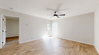 This well-appointed one-bedroom, one-bathroom home in Round Rock, Texas offers a thoughtfully designed single-floor layout that maximizes functionality and comfort. Light-toned wood-look flooring flows throughout the entire space, creating a cohesive and clean aesthetic.

The open-concept living area is bright and airy, bathed in natural light from large windows and a glass-panel patio door. A ceiling fan with integrated lighting adds both comfort and style to the space. The living room connects seamlessly to the kitchen, which features sleek gray cabinetry, white countertops, a subway tile backsplash, and stainless steel appliances including a range, microwave, and refrigerator. A peninsula counter separates the kitchen from the living area, offering additional prep and serving space.

The bedroom is a comfortable retreat with its own ceiling fan, closet access, and neutral tones throughout. The bathroom is elegantly finished with gray-green cabinetry, a white countertop, matte black hardware and fixtures, and a tiled tub-shower surround. Three closets provide generous storage throughout the home.

A private patio offers outdoor access, extending the living space. The overall design is clean, modern, and move-in ready, making this home an excellent option in the Round Rock area.