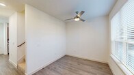 Located at 10030 Garland Rd in Dallas, TX, this modern three-story home offers three bedrooms, two bathrooms, and a thoughtfully designed layout spread across three well-proportioned floors. Light wood-look flooring flows through the main living areas, complementing the clean, contemporary aesthetic found throughout the space.

The kitchen is a standout feature, outfitted with sleek wood-toned cabinetry, a subway tile backsplash, white quartz countertops, and a full suite of stainless steel appliances including a side-by-side refrigerator, range, microwave, and dishwasher. Natural light enters through multiple windows, enhancing the bright, open feel.

The bedrooms offer comfortable, carpeted floors and ceiling fans for year-round comfort. The primary bedroom includes access to a walk-in closet with built-in shelving. A secondary bedroom also features a dedicated closet. An in-unit laundry closet with a full-size washer and dryer adds everyday convenience.

Both bathrooms are finished with large-format marble-look tile. The primary bath impresses with a dual-sink vanity featuring warm wood cabinetry, a glass-enclosed walk-in shower, and ample counter space. The secondary bath includes a soaking tub with elegant tiled surround. Hallways and staircases connect each floor seamlessly, completing this well-appointed multi-story home.