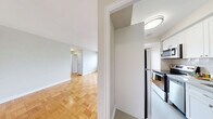 Located on the 9th floor at 565 Avenue Rd in Toronto's sought-after midtown neighbourhood, this 2-bedroom, 1-bathroom unit offers a well-organized layout across a single floor. Warm parquet flooring runs throughout the living spaces and bedrooms, lending a classic character to the interior. The living room is generously proportioned, benefiting from large windows that bring in natural light and a ceiling fan overhead. Views from the unit look out over the surrounding residential and greenery-filled streetscape of Avenue Road. The galley-style kitchen is efficiently designed, featuring white shaker cabinetry, stone-look countertops, a subway tile backsplash, and stainless steel appliances including a refrigerator, stove, and built-in microwave. The primary bedroom is a comfortable size with a large sliding-door closet, while the second bedroom includes built-in shelving and a radiator beneath its window. Both bedrooms share access to the 4-piece bathroom, which is finished with large-format neutral tiles and a decorative glass tile accent band above the soaker tub. Neutral grey-toned walls throughout the unit provide a clean, move-in ready backdrop suitable for a variety of interior styles.