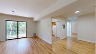 Located at 2110 Sunnyview Oval in Fords, NJ, this well-maintained one-bedroom, one-bathroom residence offers a thoughtfully laid-out floor plan with a comfortable sense of space throughout. Warm-toned hardwood floors run continuously across the living areas, dining room, and bedroom, lending a cohesive and inviting aesthetic to the entire home.

The open living and dining area is bright and airy, with clean white walls and natural light filtering in from a sliding glass door that opens directly onto a private balcony overlooking lush, mature greenery. The kitchen is efficiently designed, featuring warm oak cabinetry, white appliances including a gas range, dishwasher, and refrigerator, subway tile backsplash, and a window that brings in additional natural light.

The spacious primary bedroom offers ample room and includes multiple closets for generous storage. The full bathroom is finished with tiled flooring, white wall tiles with a decorative border, a combined tub and shower with a sliding glass enclosure, and a wood-toned vanity. Additional highlights include a dedicated laundry area, a utility room, a hallway connecting the key spaces, and a staircase with classic hardwood treads and white risers. Three closets throughout provide practical storage solutions.
