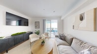Located on Van Nuys Boulevard in Los Angeles, this well-appointed one-bedroom, one-bathroom unit offers a thoughtfully designed open-concept layout. The combined kitchen and living area forms the heart of the space, where light wood-style flooring, crisp white walls, and abundant natural light create a bright, airy atmosphere. The kitchen is outfitted with gray shaker-style cabinetry, stainless steel appliances including a refrigerator, dishwasher, and range, and clean white countertops — all flowing seamlessly into the dining and living areas. Sliding glass doors in the living room open directly onto a private balcony, extending the living space outdoors with open views of the surrounding neighborhood. The spacious bedroom features large windows with blinds that invite generous natural light, light wood flooring, and a serene, neutral palette. The bathroom is finished with gray cabinetry, a white countertop vanity, a large mirror, and wood-style flooring, complemented by a shower with a decorative curtain. A dedicated closet and hallway complete the layout. The unit's modern, minimalist design and cohesive neutral tones offer a comfortable and functional living environment in the heart of the San Fernando Valley.